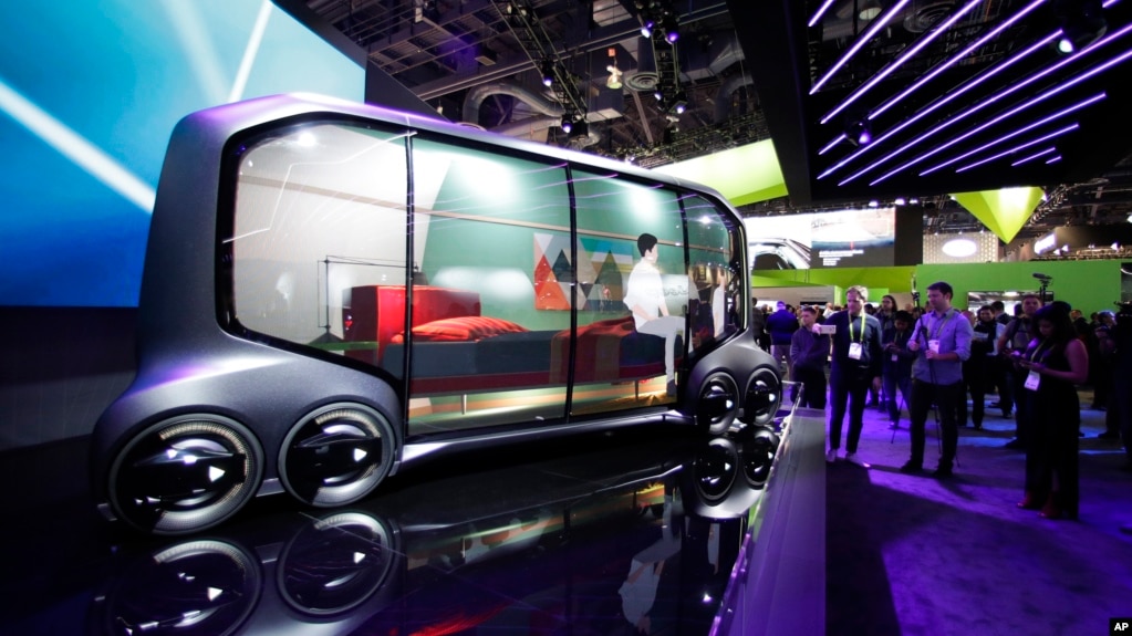 Attendees look at the Toyota e-Pallet concept at CES International, Tuesday, Jan. 9, 2018, in Las Vegas. (AP Photo/Jae C. Hong)