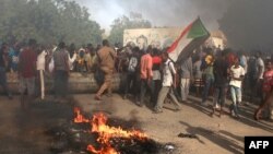 Sudanese men protest against a military coup that overthrew the transition to civilian rule, in the al-Shajara district in southern Khartoum, on October 25, 2021.