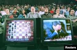 FILE - World chess champion Garry Kasparov rests his head in his hands as he is seen on a monitor during game six of the chess match against IBM supercomputer Deep Blue, May 11, 1997.