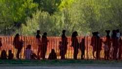 n this March 19, 2021, file photo, migrants are seen in custody at a U.S. Customs and Border Protection processing area under the Anzalduas International Bridge, in Mission, Texas.