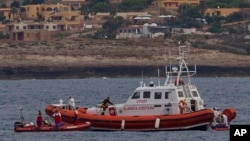 Italian Coast Guard personnel recover a body bag on their patrol boat in Lampedusa island, Oct. 8, 2013.