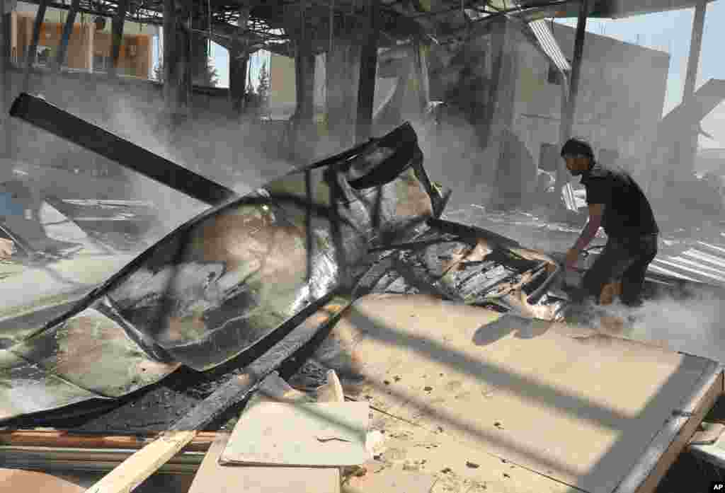 一名叙利亚男子在德罗沙沙特阿拉伯电视台被烧毁的一房间内。（叙利亚阿拉伯电视台提供照片）