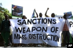 FILE: Zimbabwe's ruling party Zanu PF war veterans march past the US Embassy holding placards condemning sanctions against their government in Harare, Zimbabwe, Apr 23, 2010.