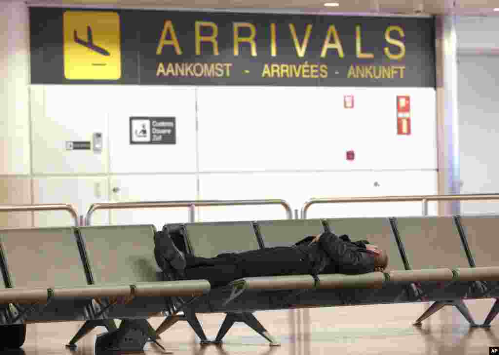 A man rests on a bench at an empty Brussels airport due to trade unions capping a month of labor action against government austerity policies with a general strike that has paralyzed air and rail traffic and idled companies throughout Belgium, Dec. 15, 2014.