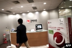 FILE - An employee of Japan-based Trend Micro cybersecurity research group walks toward a reception desk at the entrance of the company's headquarters in Tokyo, April 25, 2017.