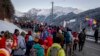 Cientos de manifestantes pasan por la ciudad de Klosters, en vía a Davos, Suiza. Lunes, 20 de enero, 2020.