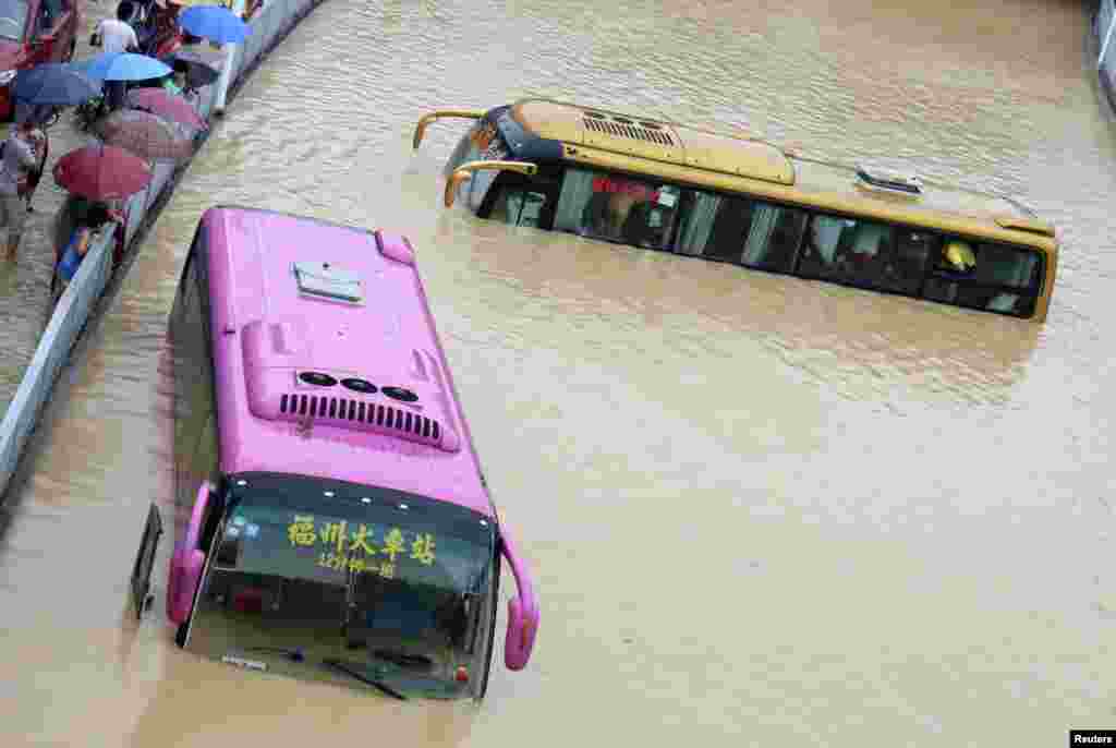 Buses are stranded in a flooded street in Fuzhou, Fujian province, China. Typhoon Matm headed into China after hitting Taiwan and it was downgraded from typhoon to tropical storm.