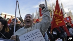 A protester wearing a sign reading "unemployed" shouts slogans during a metalworkers protest in front of the Duomo gothic cathedral, in Milan, Italy, December 5, 2012.