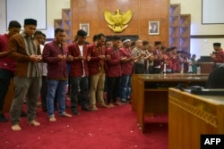 Para mahasiswa peserta demo dan pejabat kepolisi mendoakan korban unjuk rasa menentang berbagai RUU kontroversial, di ruang DPR Aceh, di Banda Aceh, 27 September 2019. (Foto: Chaideer Mahduddin/AFP)