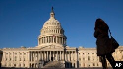 FILE - A woman looks at the U.S. Capitol in Washington. The White House says a bill that seeks to bar the U.S. from lifting certain sanctions against Iran would violate commitments necessary to implement the international agreement to limit the Iranian nuclear program.