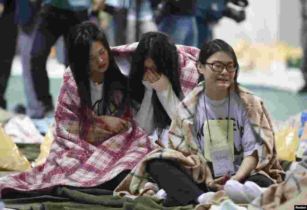 Passageiros resgatados choram num ginásio que serve de abrigo para eles, em Jindo, Coreia do Sul, Abril 16, 2014.