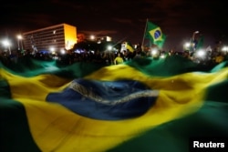 Supporters of Jair Bolsonaro, far-right lawmaker and presidential candidate of the Social Liberal Party (PSL), react after Bolsonaro wins the presidential race, in Brasilia, Brazil, Oct. 28, 2018.