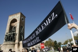 Lecturers from the Istanbul Technical University display a black banner that reads: "Terror can't divide our nation, We are together." during a protest in Istanbul, Turkey, Oct. 17, 2007.