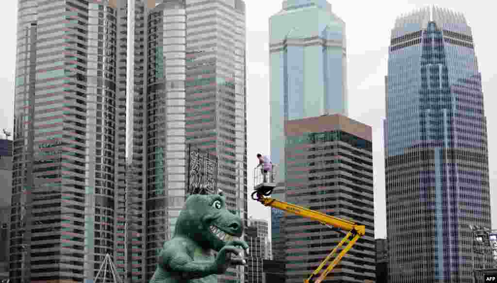 A worker secures ropes to a large sculpture that will be part of the new Lai Chi Kok amusement part in Hong Kong.