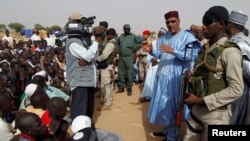 FILE - Niger's Interior Minister Mohamed Bazoum speaks to displaced people in a camp of the city of Diffa, following attacks by Boko Haram fighters in the region, June 18,2016.