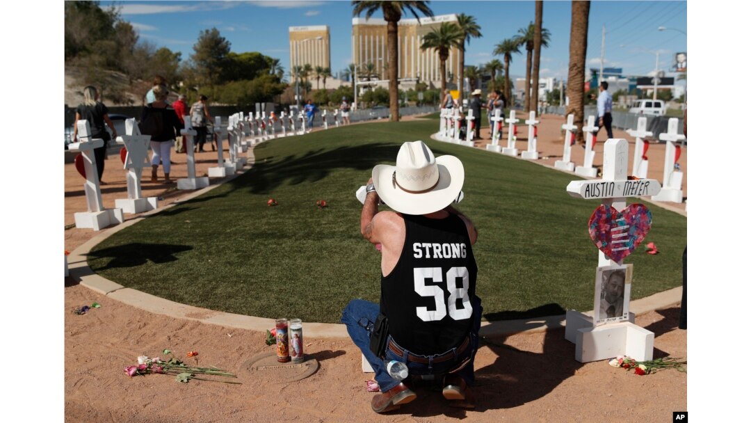 Jim Strickland, de Oroville, California, escribe un mensaje en una cruz en un monumento improvisado para las víctimas del tiroteo masivo del 1 de octubre de 2017 en Las Vegas, el domingo 30 de septiembre de 2018 en Las Vegas. "Necesitaba un cierre, así que tuve que volver", dijo Strickland, que estaba en el festival de música y regresó para el aniversario. (AP Photo / John Locher)