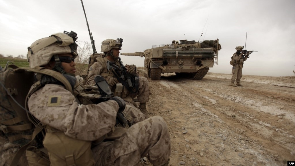 资料照片：美国海军陆战队在阿富汗马尔亚城边东北方一条交通要道巡逻时经过一辆正在清除土制炸弹的丹麦陆军豹2A5坦克。（2010年2月21日）(photo:VOA)