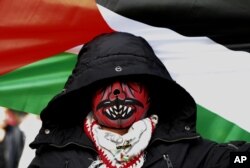 FILE - A masked protester waves a Palestinian flag during a demonstration in Beirut to denounce the widely criticized decision by U.S. President Trump to recognize Jerusalem as the capital of Israel, Dec. 8, 2017.