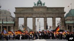 AfD supporters wave flags in front of the Brandenburg Gate in Berlin, Germany, May 27, 2018. The AfD swept into Parliament last year on a wave of anti-migrant sentiment.