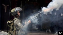 Seorang polisi Israel menembakkan gas air mata ke arah demonstran Palestina di kota al-Ram, utara Yerusalem, Kamis (22/10).