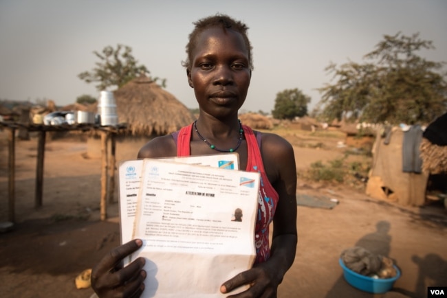Grace Gaba holds her brother's refugee registration card in a camp for South Sudanese refugees in Aba, Democratic Republic of Congo. (J. Patinkin for VOA)