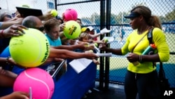 Serena Williams firma autógrafos antes de que comience el Abierto de Estados Unidos, en Nueva York.