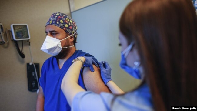 In this Oct. 9, 2020, file photo, a health worker, right, administers the first dose of a COVID-19 vaccine currently on phase III clinical trials to Cem Gun, an emergency medicine physician at the Acibadem Hospital in Istanbul.(AP Photo/Emrah Gurel, File