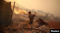 Un homme aide à éteindre un incendie à Pedreira, près de Silves, au Portugal