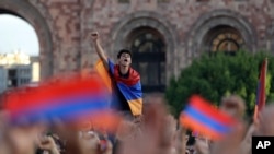 Supporters of opposition lawmaker Nikol Pashinian carry Armenian flags as they protest in Republic Square in Yerevan on May 2, 2018.