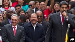 FILE - Cuba's President Raul Castro, left, and Nicaragua's President Daniel Ortega, second left, listen to a speech by Venezuela's President Nicolas Maduro, outside of Miraflores palace during a rally in Caracas, Venezuela, March 5, 2018. 