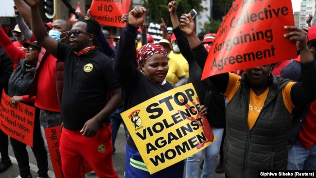 "STOP à la violence contre les femmes", lit-on sur une pancarte lors de la grève générale d'un jour lancée par les centrales syndicales sud-africaines devant le Parlement à Johannesburg, en Afrique du Sud, le 7 octobre 2020.