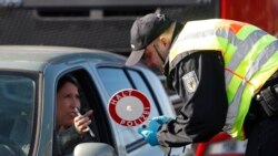Nemački policajac proverava dozvolu žene koja ulazi u Nemačku iz Francuske.