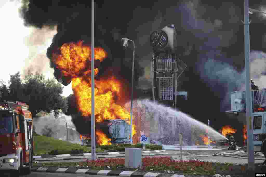 Israeli fire-fighters extinguish a fire that broke out after a rocket hit a gas station in the southern Israeli city of Ashdod, July 11, 2014. 