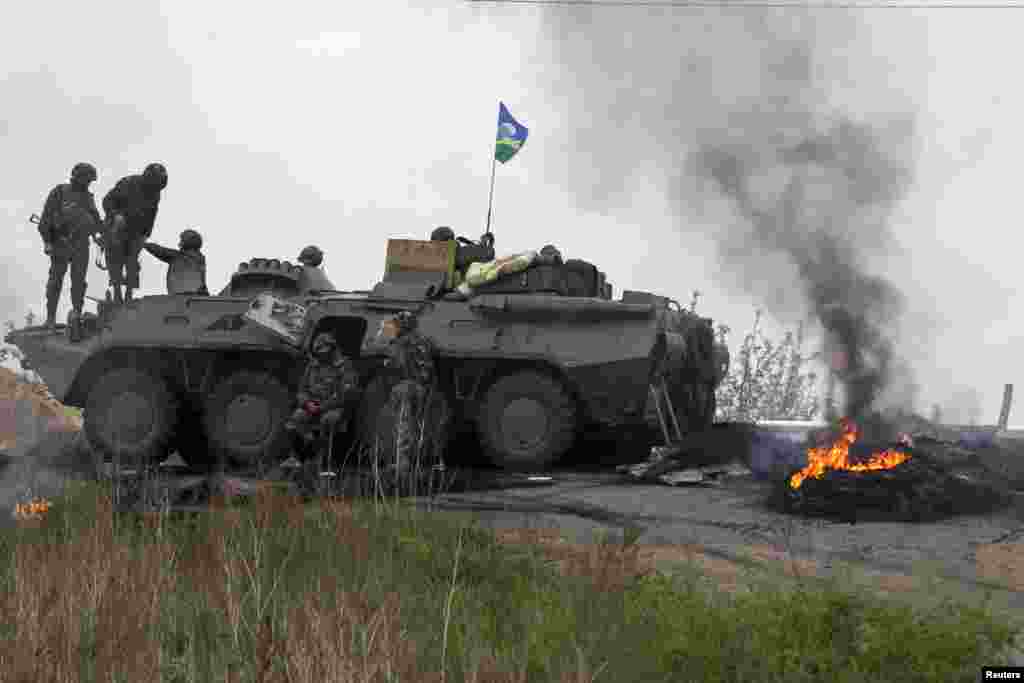 Ukrainian troops guard a checkpoint near the town of Slaviansk in eastern Ukraine May 2, 2014. Ukrainian forces attacked the rebel-held city of Slaviansk before dawn on Friday and pro-Russia separatists shot down at least one attack helicopter, killing a pilot.