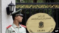 A paramilitary policeman stands guard at the entrance of the Libyan Embassy in Beijing, August 23, 2011