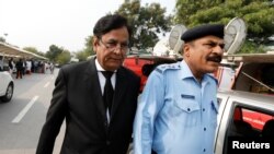 FILE - Saiful Mulook, left, the lawyer for a Christian woman sentenced to death for blasphemy against Islam, leaves after the a court overturned the conviction, in Islamabad, Pakistan, Oct. 31, 2018. 