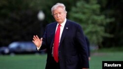 FILE - U.S. President Donald Trump waves as walks on the South Lawn of the White House upon his return to Washington, from the G-20 Summit in Hamburg, July 8, 2017. 