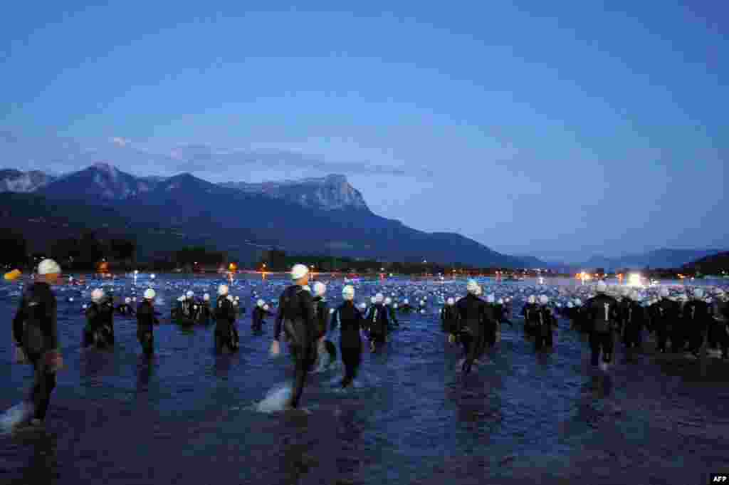 Competitors take the start of the swimming event during the 30th edition of the Embrunman triathlon in Embrun, southeastern France. The Embrunman is considered as one of the hardest triathlon events with a swim of 3.8km followed by a 188-km cycle ride and a 42-km marathon.