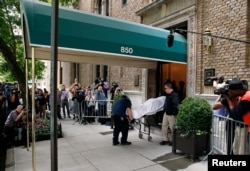 Medical examiners remove the body from the Park Avenue apartment of designer Kate Spade in New York, June 5, 2018.