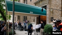 Medical examiners remove the body from the New York City home of designer Kate Spade, June 5, 2018.