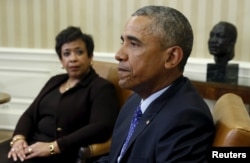 U.S. Attorney General Loretta Lynch (left) looks toward U.S. President Barack Obama during a meeting in the Oval Office of the White House in Washington, Jan. 4, 2016. Behind Obama is a bust of Martin Luther King Jr.