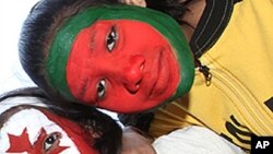 Two school children with their faces painted in the colors of the national flags of the countries participating in the upcoming Cricket World Cup in the northern Indian city of Lucknow.