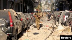 Anggota pasukan keamanan Lebanon melewati puing-puing dekat lokasi terjadinya ledakan di Beirut (5/8). 