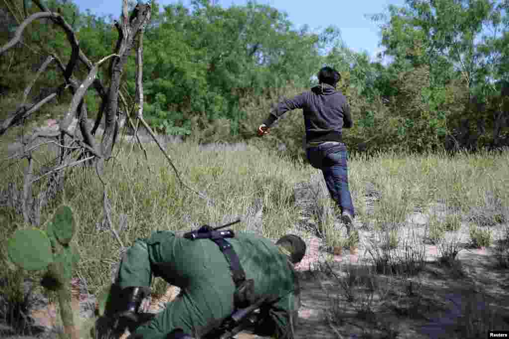 A man who illegally crossed the Mexico-U.S. border evades a U.S. Border Patrol agent near McAllen, Texas, May 8, 2018.