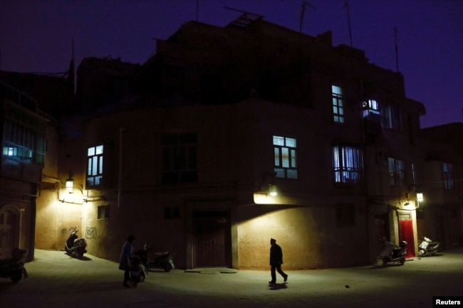 A man walks along a street at night in the old town of Kashgar, Xinjiang Uighur Autonomous Region, China, March 23, 2017. Thousands of "convenience police stations" have been built across Xinjiang. They are typically just hundreds of meters apart in what party boss Chen Quanguo calls a "grid-style social management system."