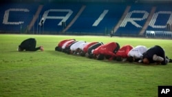 Players of the Egyptian national soccer squad and team officials pray at Cairo's stadium, Egypt, Monday, Nov. 6, 2017, before training to prepare for their Nov. 12 away game against Ghana, in the last African Group E World Cup qualifier.