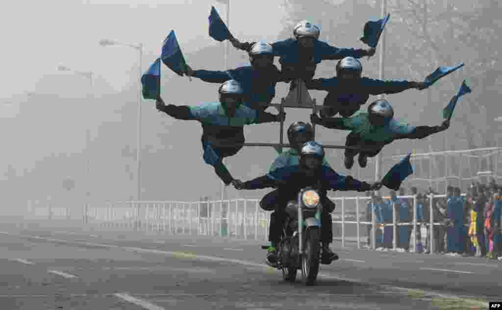 Indian army personel perform acrobatics on their bikes as they take part in a rehearsal ahead of the forthcoming Republic Day parade in Kolkata.