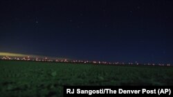 This Jan. 2, 2020, photo shows red lights from wind turbines in the distance in the area of Genoa and Hugo, Colorado, where sightings of unidentified large drones in the air have been reported.