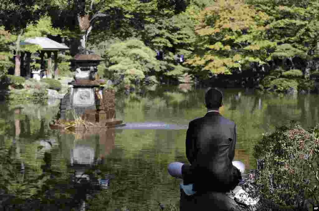A man sits on a stone and meditates at Hibiya park in Tokyo, Japan. The park has been a military training ground until 1903 when the ground was converted into a modern public park. 