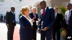 Haiti's President Jovenel Moise, right, talks with Chile's President Michelle Bachelet as she leaves the National Palace after their meeting in Port-au-Prince, Haiti, March 27, 2017. 